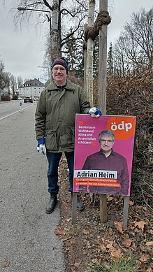 Adrian Heim stellt erste Plakatständer in der Stadt Dachau auf